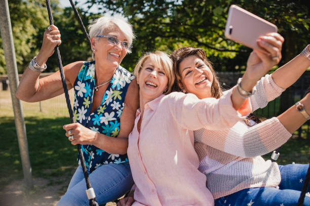 istock Senior Women Having Fun on a Swing Taking a Selfie 1034294548