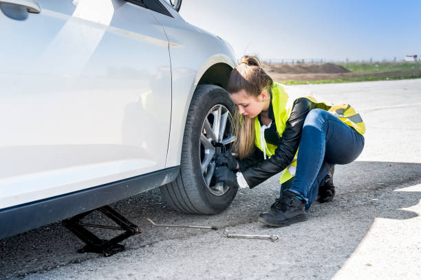 istock Woman changing damaged wheel and fixing it 1034297358