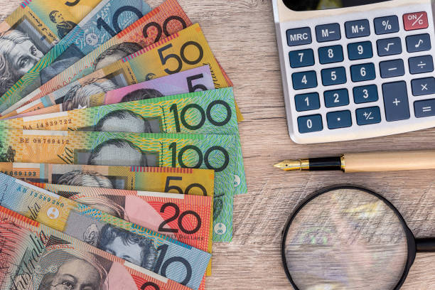 Australian dollars with calculator, pen and magnifier stock photo