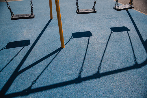 Shadows Of Swings On A Safety Playground