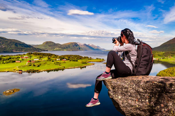 Nature photographer Norway Lofoten archipelago. Nature photographer tourist with camera shoots while standing on top of the mountain. Beautiful Nature Norway Lofoten archipelago. lofoten photos stock pictures, royalty-free photos & images