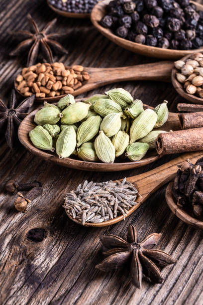 istock Different types of whole Indian spices in wooden spoons on rustic background. 1034301924