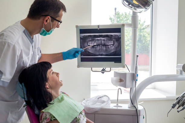 istock Dentist and patient looking at x-ray of teeth on screen 1034302452