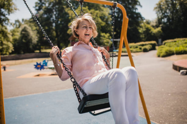 istock Senior Woman on a Children's swing 1034302498