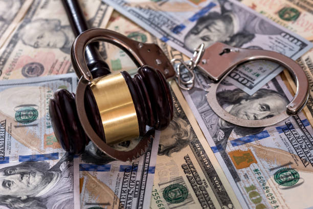 istock Steel handcuffs with judge's gavel on dollar banknotes 1034303182