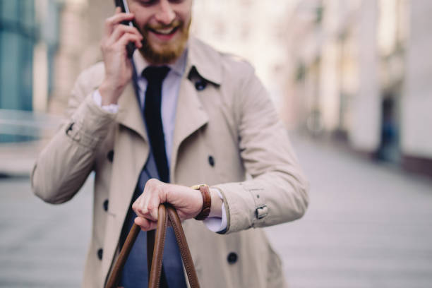 istock Businessman checking the time while talking on a mobile phone 1034309662
