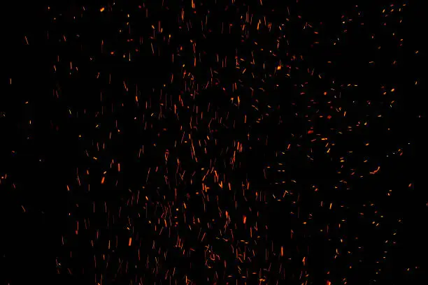 Photo of bonfire spark in the dark sky in night, shallow focus