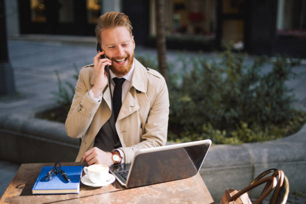 istock Smiling businessman working from a cafe 1034311126