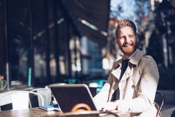istock Handsome bearded  man with a laptop at a cafe 1034314008