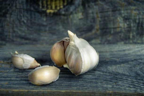 fresh garlic and some cloves of garlic close-up on wooden background stock photo