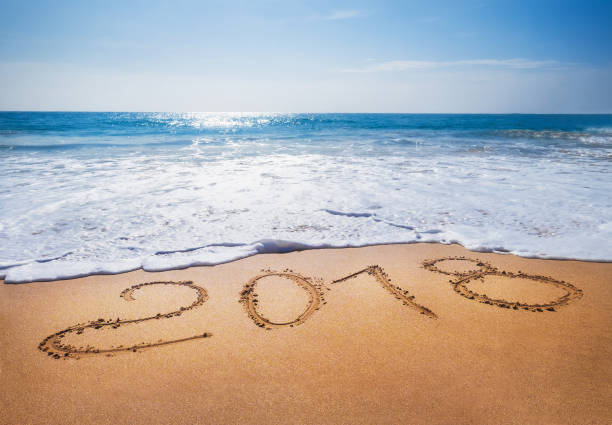 istock Old Year 2018 expires concept sandy tropical 
 ocean beach lettering concept image and Happy New Year 2019 is coming 1034322436