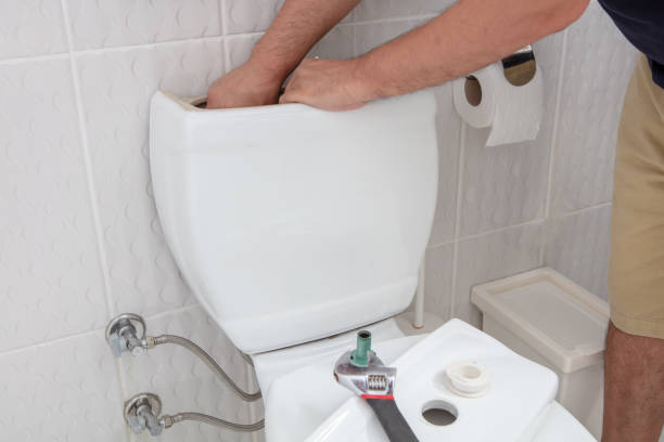 Man using hands repairing toilet cistern stock photo