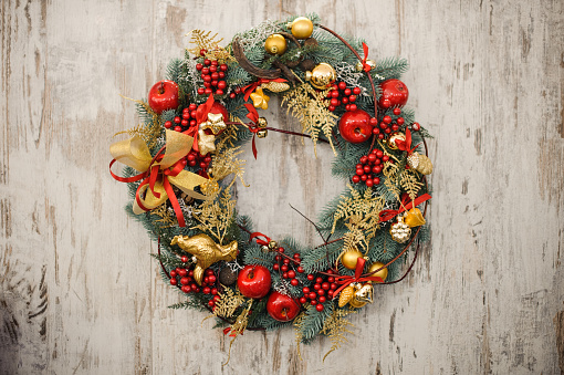 Top view of a christmas wreath with ornaments such as a candy cane, christmas balls, berries and christmas lights isolated on white background