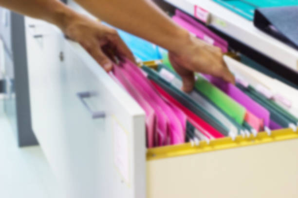 istock Blurred image man's hands Search files document of hanging file folders in drawer in a whole pile 1034337918