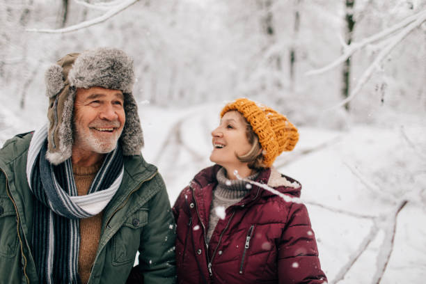 senior paar genießt einen winterspaziergang - snow walking stock-fotos und bilder
