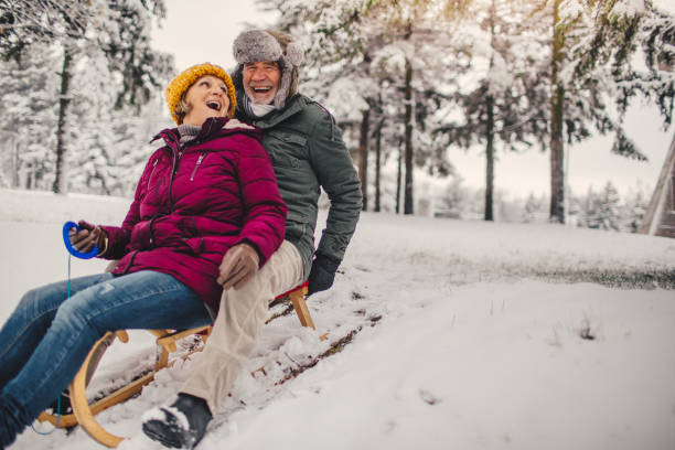 Sledding time Photo of a lovely, elderly couple who still enjoy sledding as when they were kids animal sleigh photos stock pictures, royalty-free photos & images