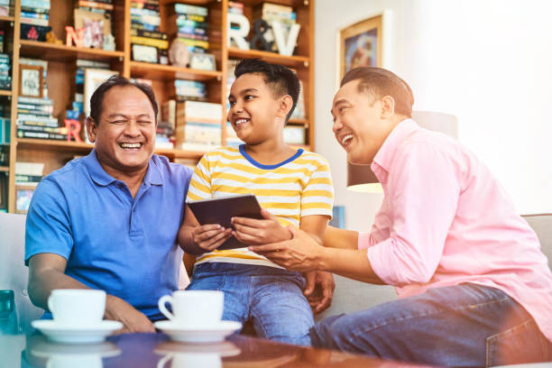 istock Happy family with tablet PC on sofa at home 1034347122