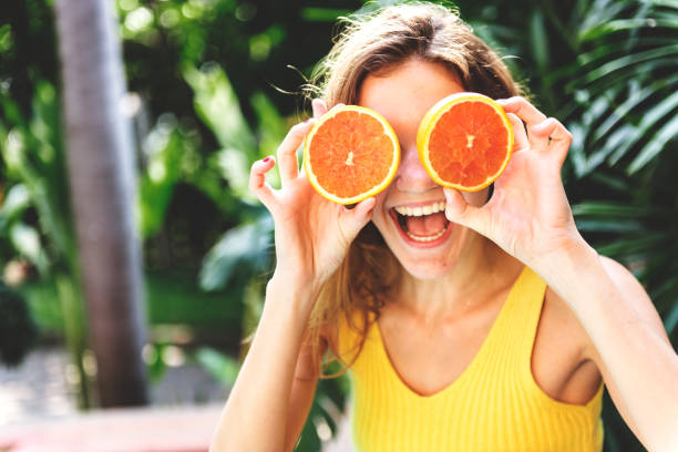 istock Happy young woman with oranges 1034348242