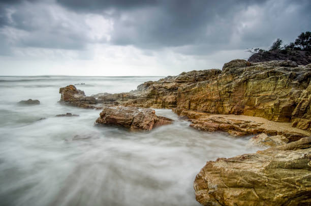 istock beautiful beach with rock hitting by waves 1034348834
