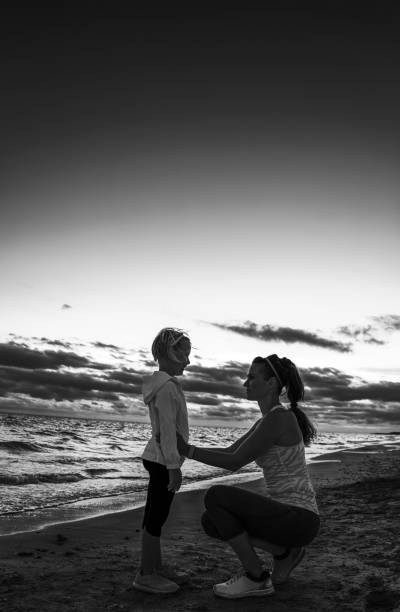 istock healthy mother and child on seashore on sunset 1034352616
