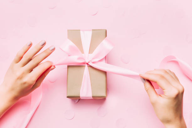 manos de hermosa mujer con hermoso manicura abren caja de regalo. - table wedding flower bow fotografías e imágenes de stock