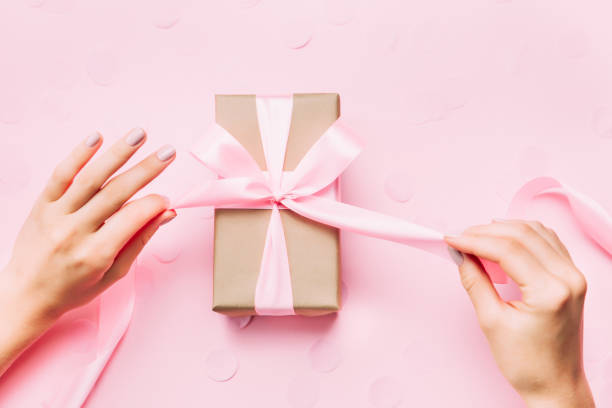 Beautiful woman hands with beautiful manicure open gift box. Beautiful woman hands with beautiful pastel manicure open gift box on pink trendy background. Holiday gift and trendy manicure concept. hand holding gift stock pictures, royalty-free photos & images