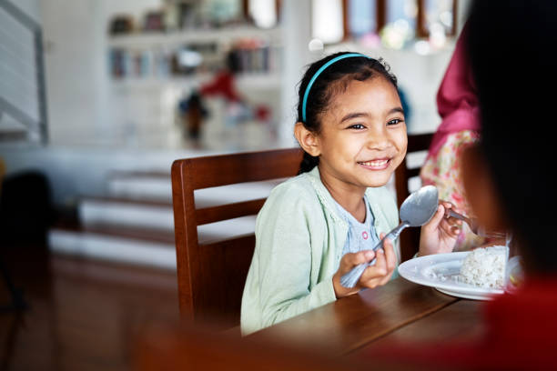 istock Smiling girl having food at table 1034356468