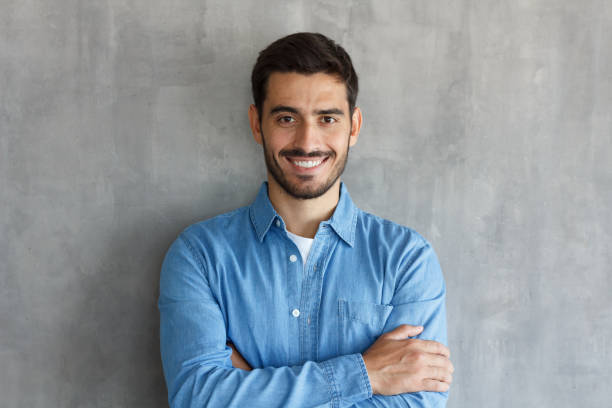 istock Horizontal shot of handsome Caucasian guy pictured isolated on grey background standing with arms crossed in casual clothes, looking confident and optimistic, smiling friendly and happily while posing 1034357456