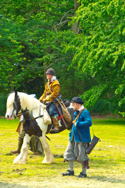 English Civil War battle re-enactment English Civil War battle re-enactment group at a Cambridgeshire Village fete. The event was part of the Kimbolton Fayre and Classic car show at Kimbolton School, Cambridgeshire. There was no fee to see the parade by the troops. civil war enactment stock pictures, royalty-free photos & images