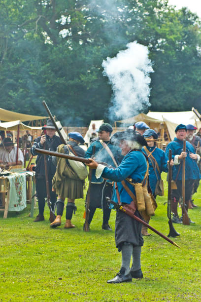 English Civil War battle re-enactment English Civil War battle re-enactment group at a Cambridgeshire Village fete. The event was part of the Kimbolton Fayre and Classic car show at Kimbolton School, Cambridgeshire. There was no fee to see the parade by the troops. civil war enactment stock pictures, royalty-free photos & images