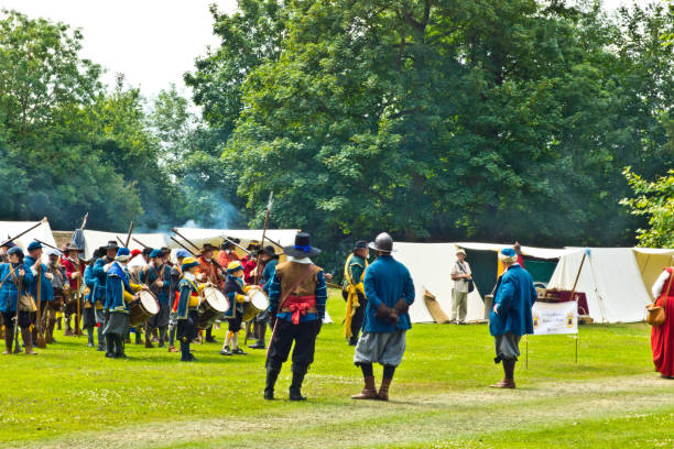 English Civil War battle re-enactment English Civil War battle re-enactment group at a Cambridgeshire Village fete. The event was part of the Kimbolton Fayre and Classic car show at Kimbolton School, Cambridgeshire. There was no fee to see the parade by the troops. civil war enactment stock pictures, royalty-free photos & images