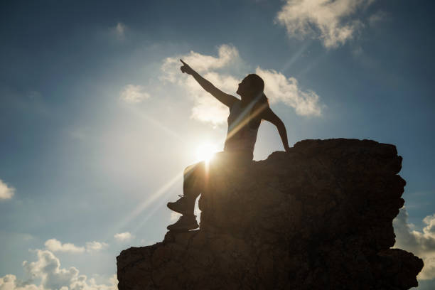 istock woman point finger to sky at hill peak 1034364256