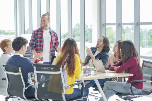 istock Happy Multi Ethnic Creative team brainstorming in smart casual wear having a meeting while standing behind the glass wall at the office 1034365952