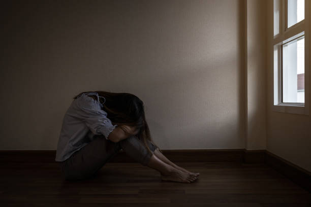 istock depressed and stressed woman sitting on the floor alone 1034372526