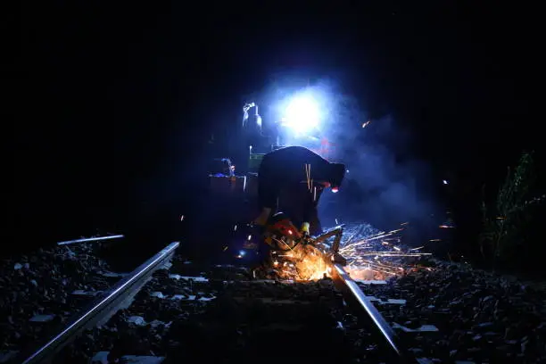 Thermit welding works on a railroad during night time