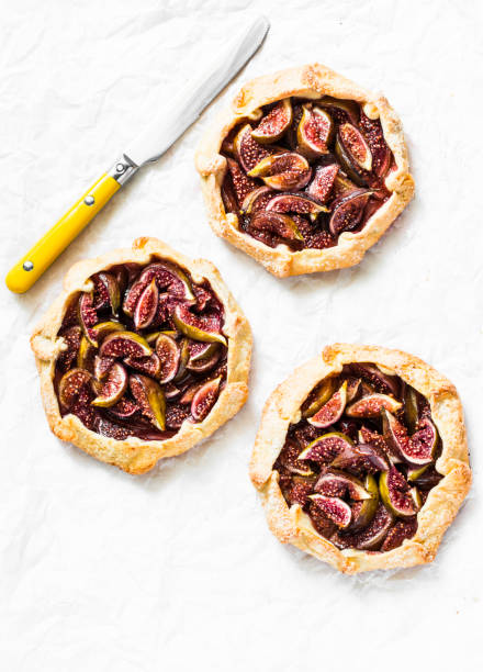 istock Caramelized figs tarts or pies on a light background, top view. Flat lay 1034376318