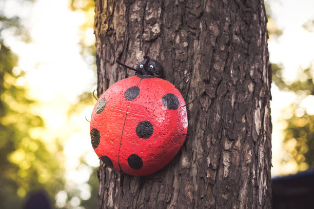 Autumn background. Ladybug garden decoration on tree