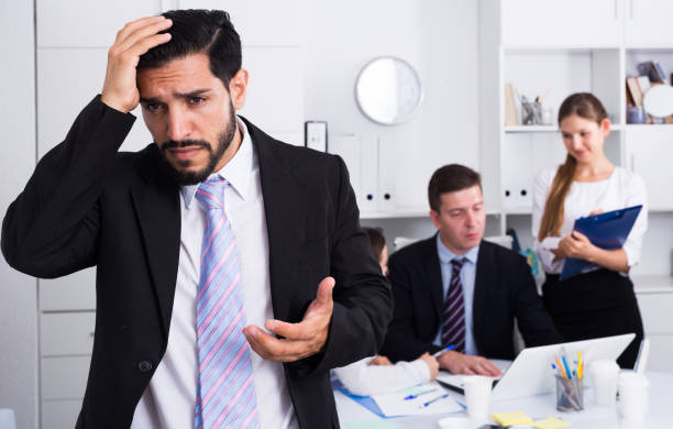 istock Tired man at office with working colleagues 1034394630