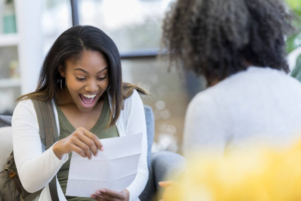 istock Excited high school student reads college acceptance letter 1034402060