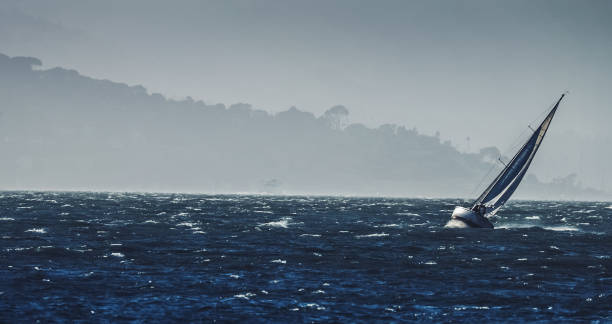 парусная лодка в шторм с огромным ветром - tilted horizon стоковые фото и изображения