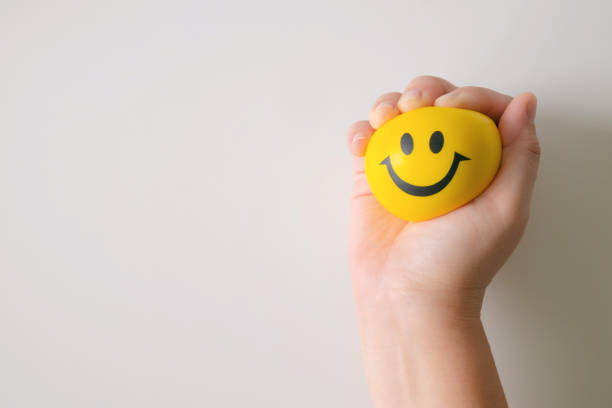 Hand squeeze yellow stress ball. Hand squeeze yellow stress ball to relax. anthropomorphic smiley face photos stock pictures, royalty-free photos & images