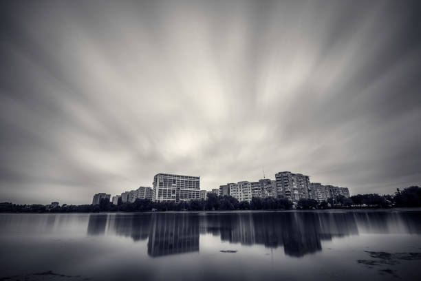Dramatic clouds long exposure during storm over the city with buildings reflecting in water