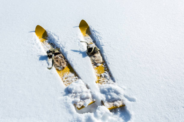 par de viejas moda madera amarillo esquís sobre la nieve blanca - ski old wood pair fotografías e imágenes de stock