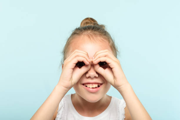 istock funny joyful playful girl pretend look binocular 1034409484