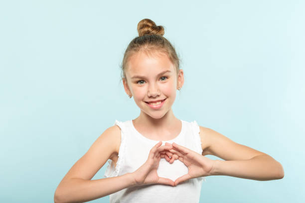 istock love emotion smiling girl making heart shape hands 1034409490