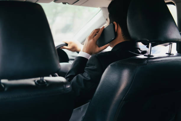 istock Young business man with phone in car. 1034415076