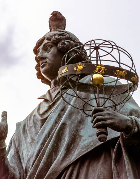 pombo, sentada na cabeça de copernicus - nicolaus copernicus monumento na cidade natal do astrónomo nicolaus copernicus - nicolaus copernicus - fotografias e filmes do acervo