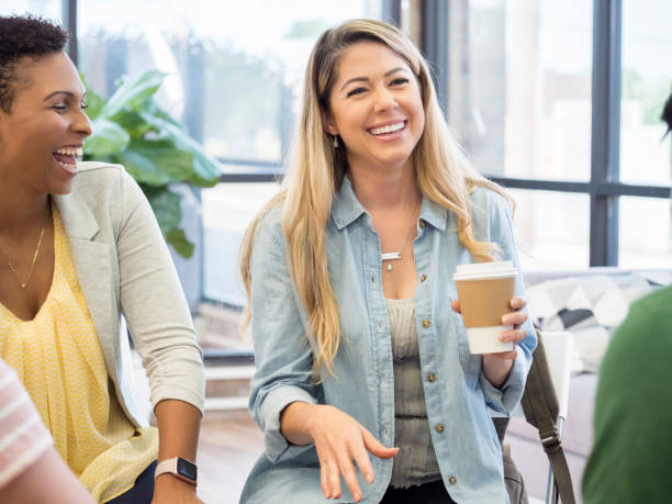 istock Cheerful woman shares a joke in group therapy 1034424582