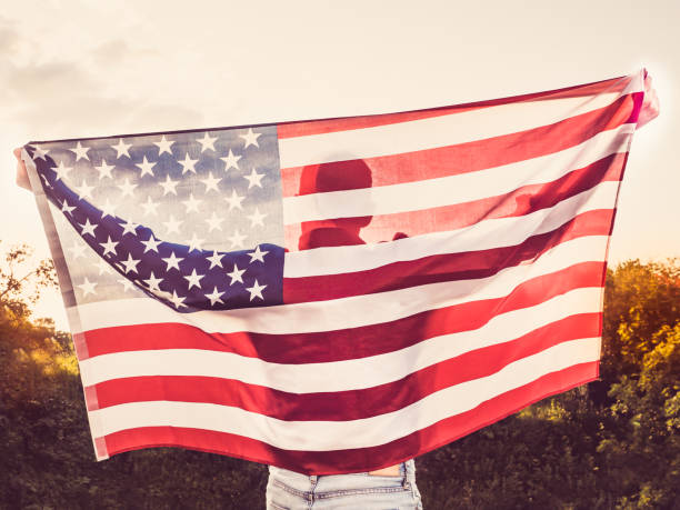 istock Attractive, young man holding a US flag 1034428244