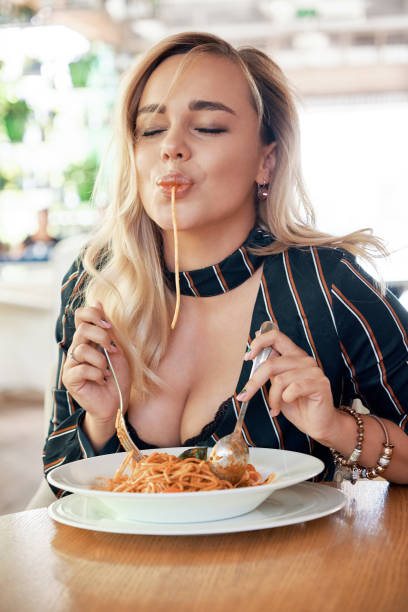 istock Seductive woman eating pasta 1034435670